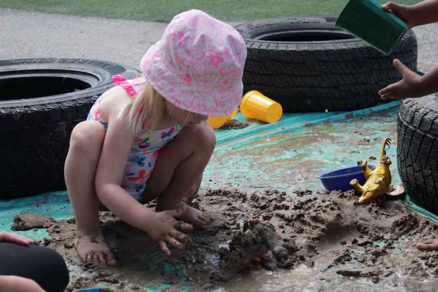 girl playing in mud on mud day